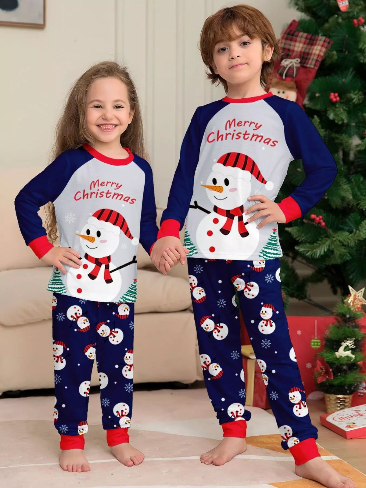 Two children wearing navy-and-white snowman Christmas pajamas.