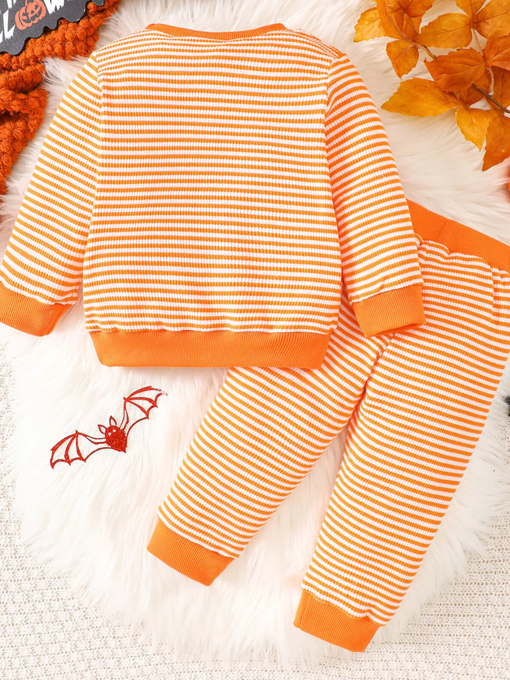 Orange striped BOO BABE pajama top and matching Halloween-print pants displayed flat