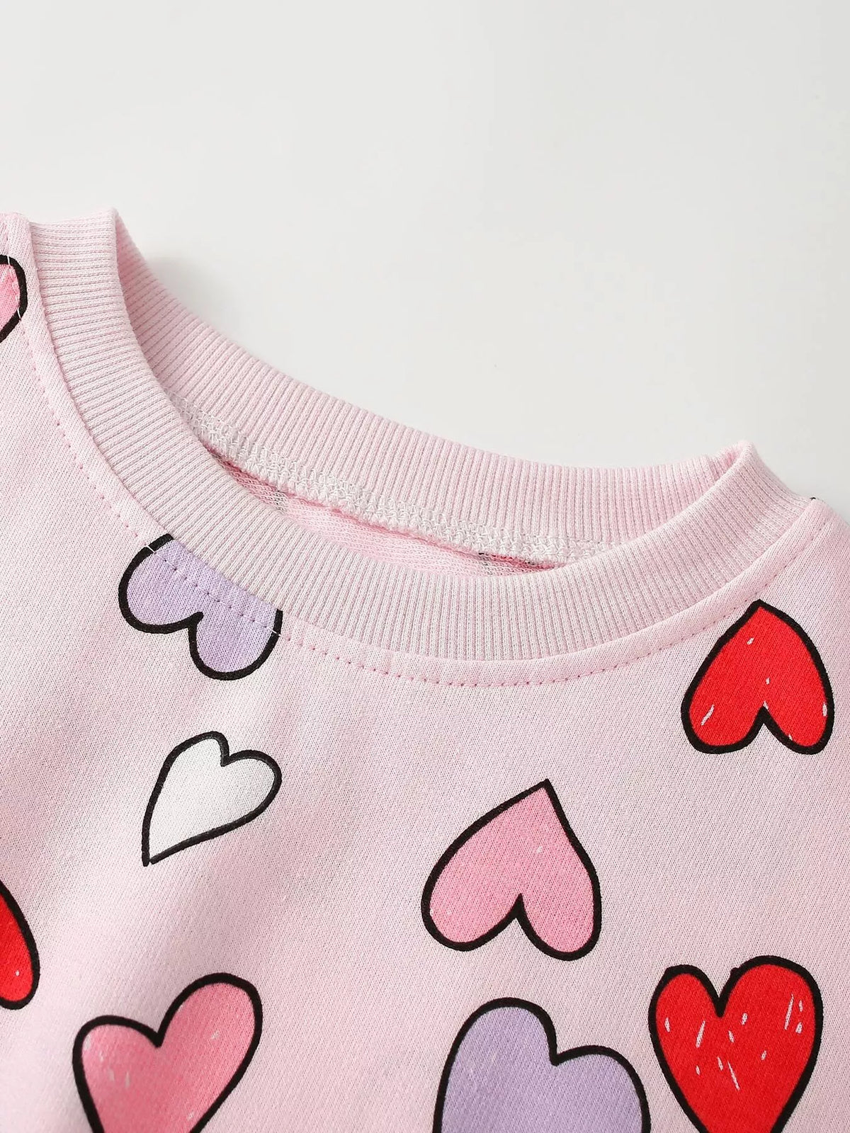 Round neckline and heart print on the pink sweatshirt