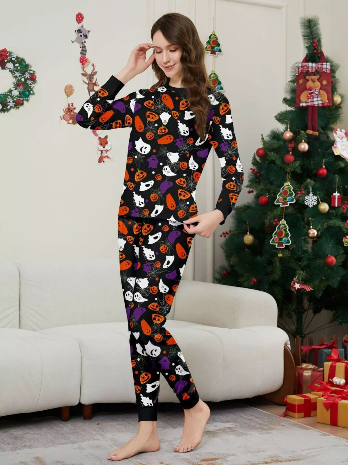 Black matching family pajamas with colorful Halloween ghost and pumpkin print worn by an adult