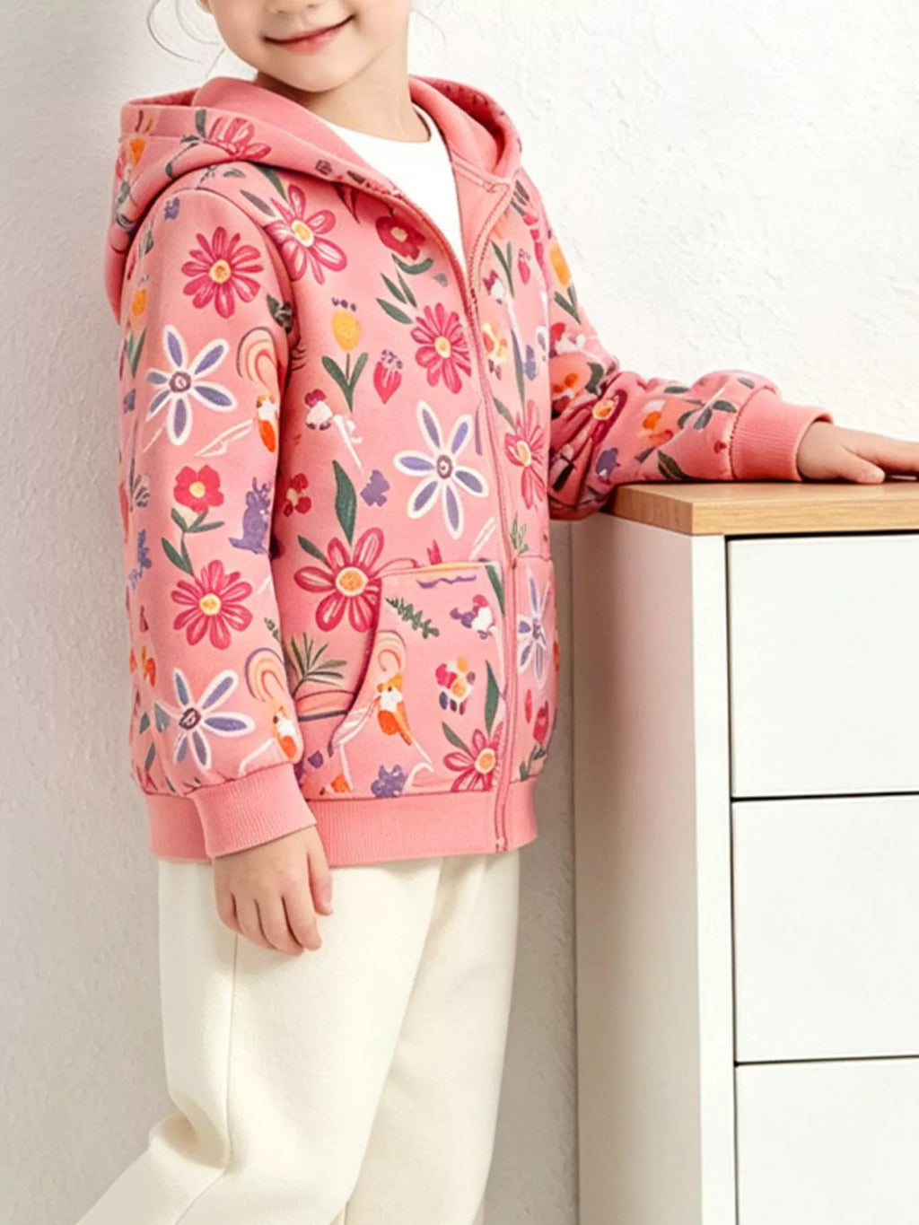Angled view of a child modeling the pink floral hooded jacket.