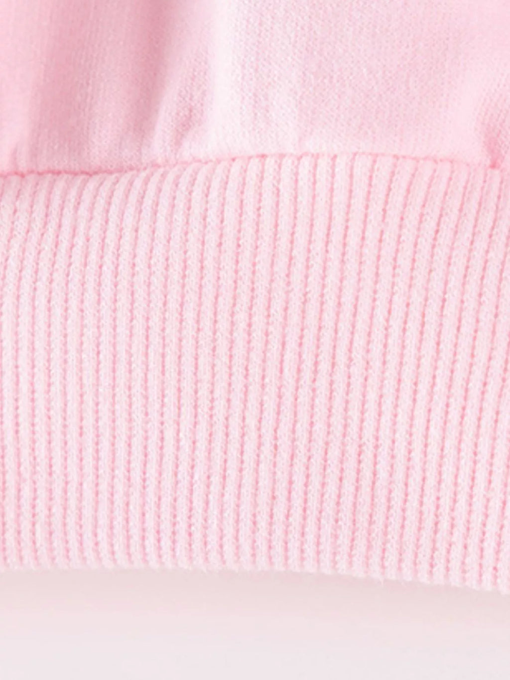 Ribbed hem detail of the pink sweatshirt