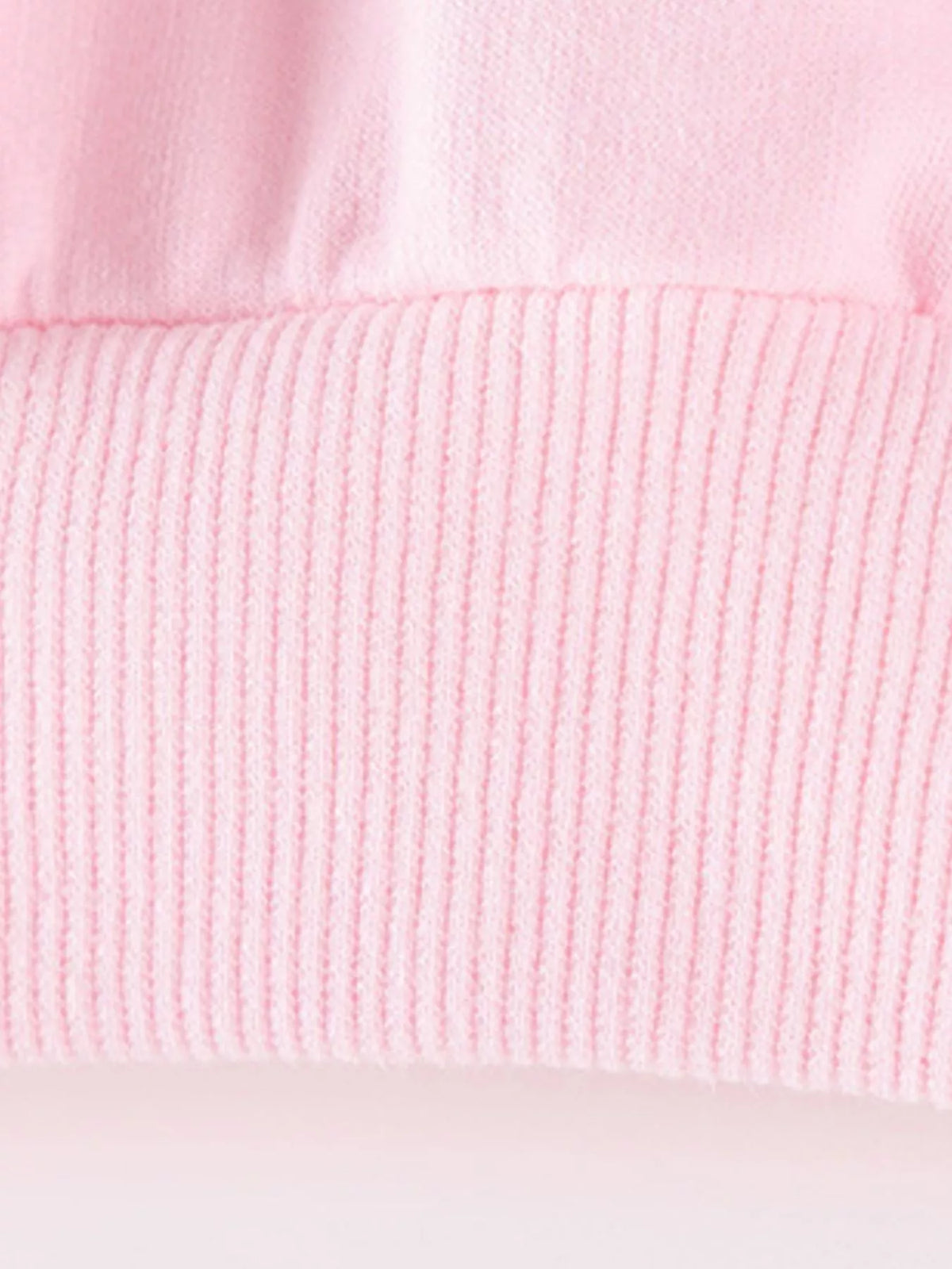 Ribbed hem detail of the pink sweatshirt