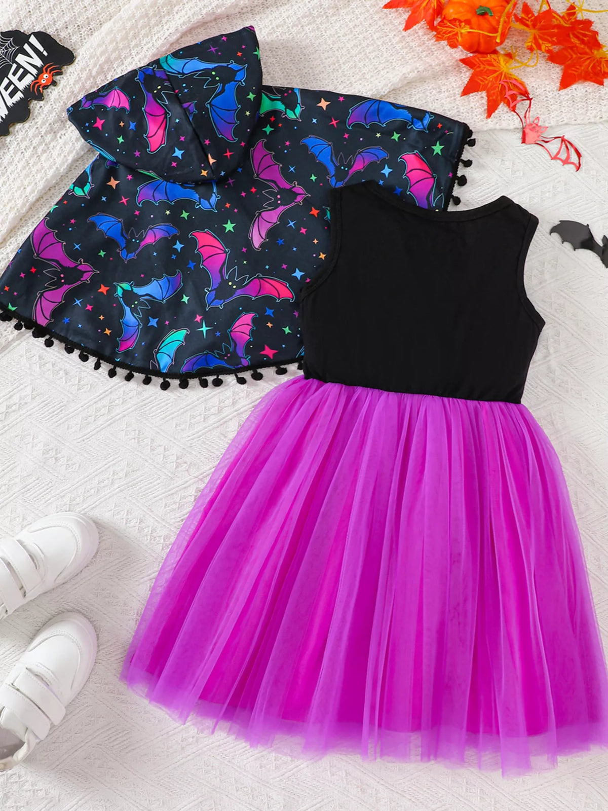 Back flat lay of the bat-print cape and purple tulle skirt dress.