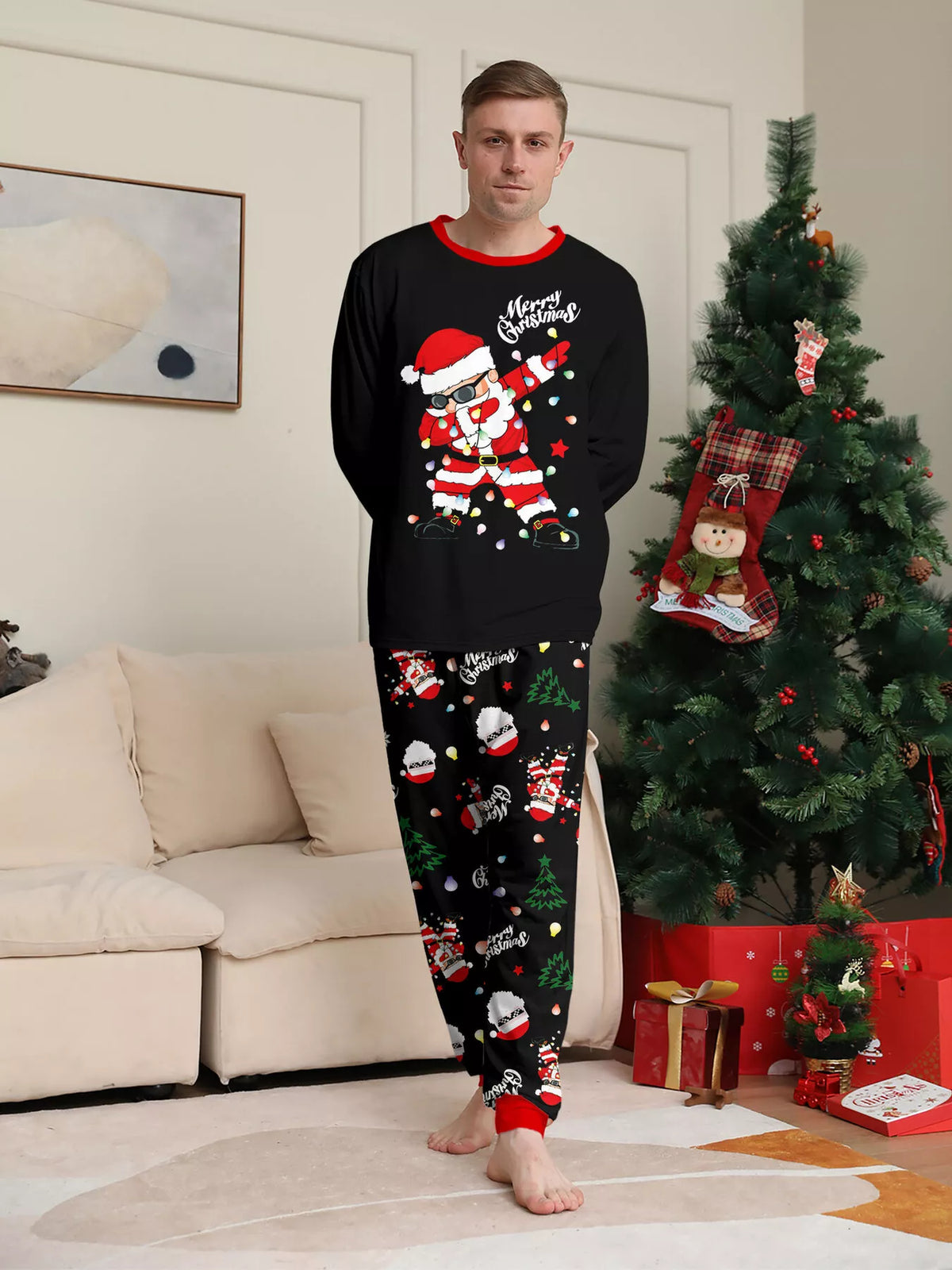 Man modeling a black Santa graphic top and black Christmas-print pajama pants.