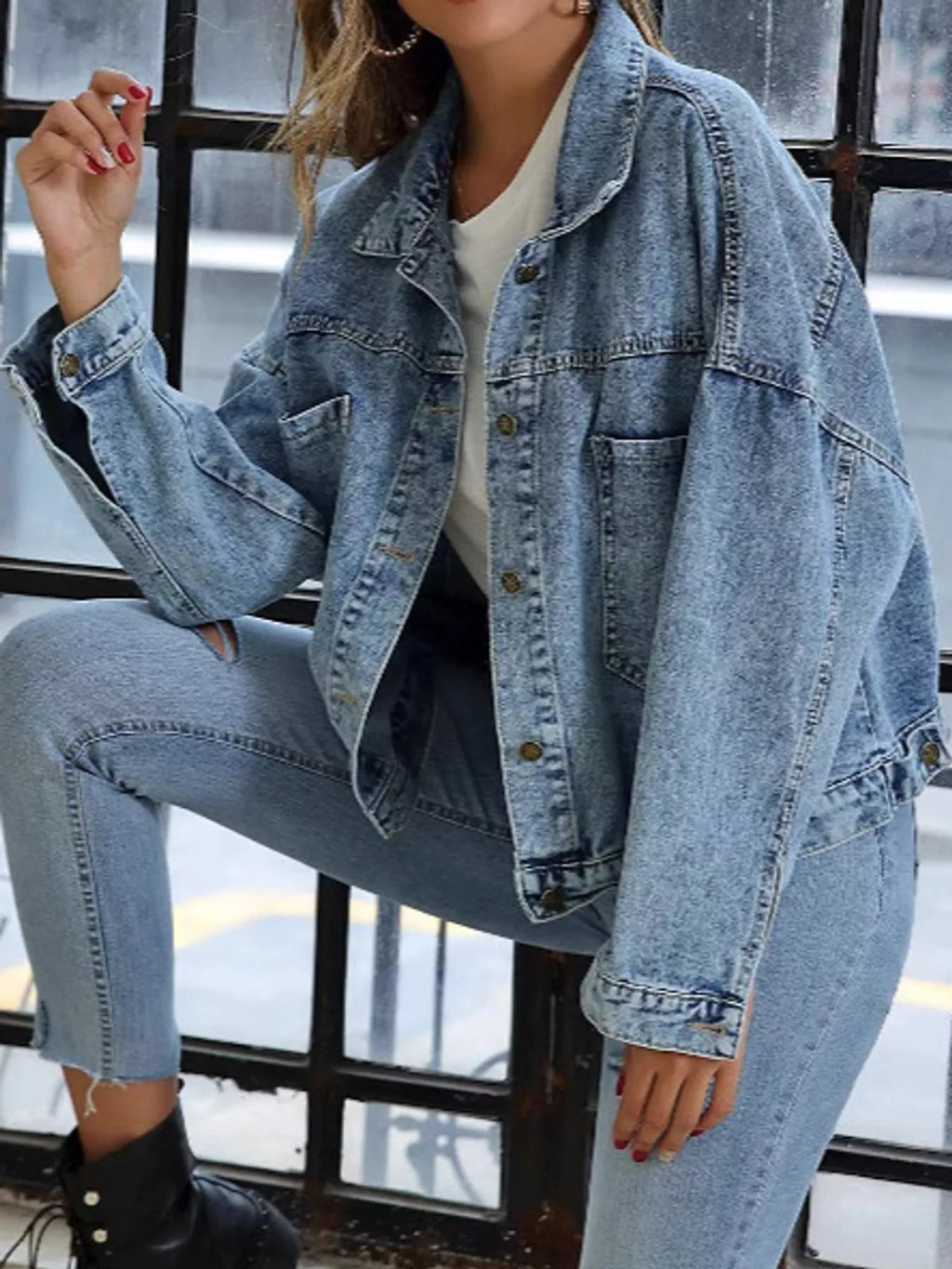 Light-blue denim jacket modeled with one knee raised.