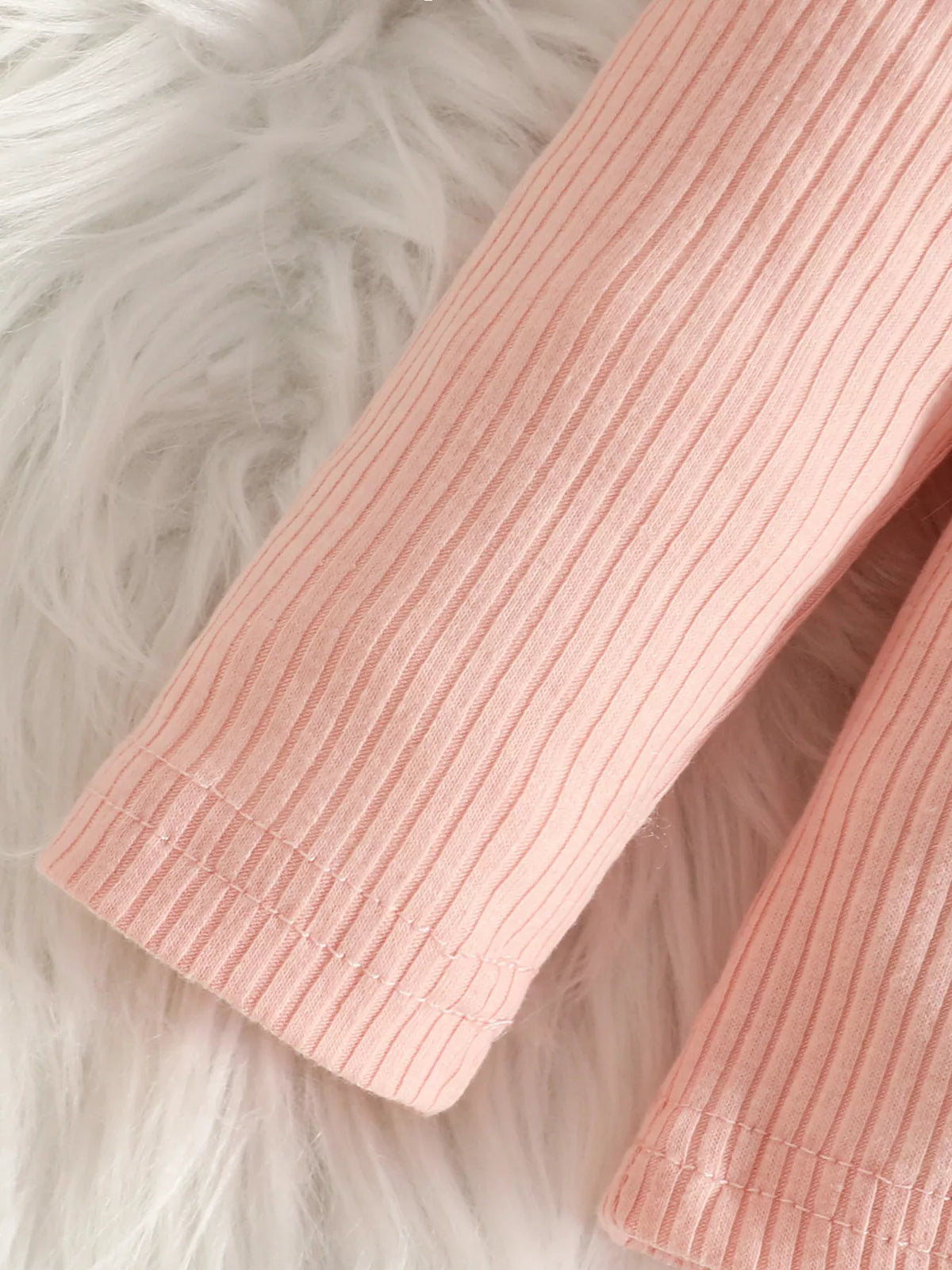Close-up of the pink top's ribbed sleeve.