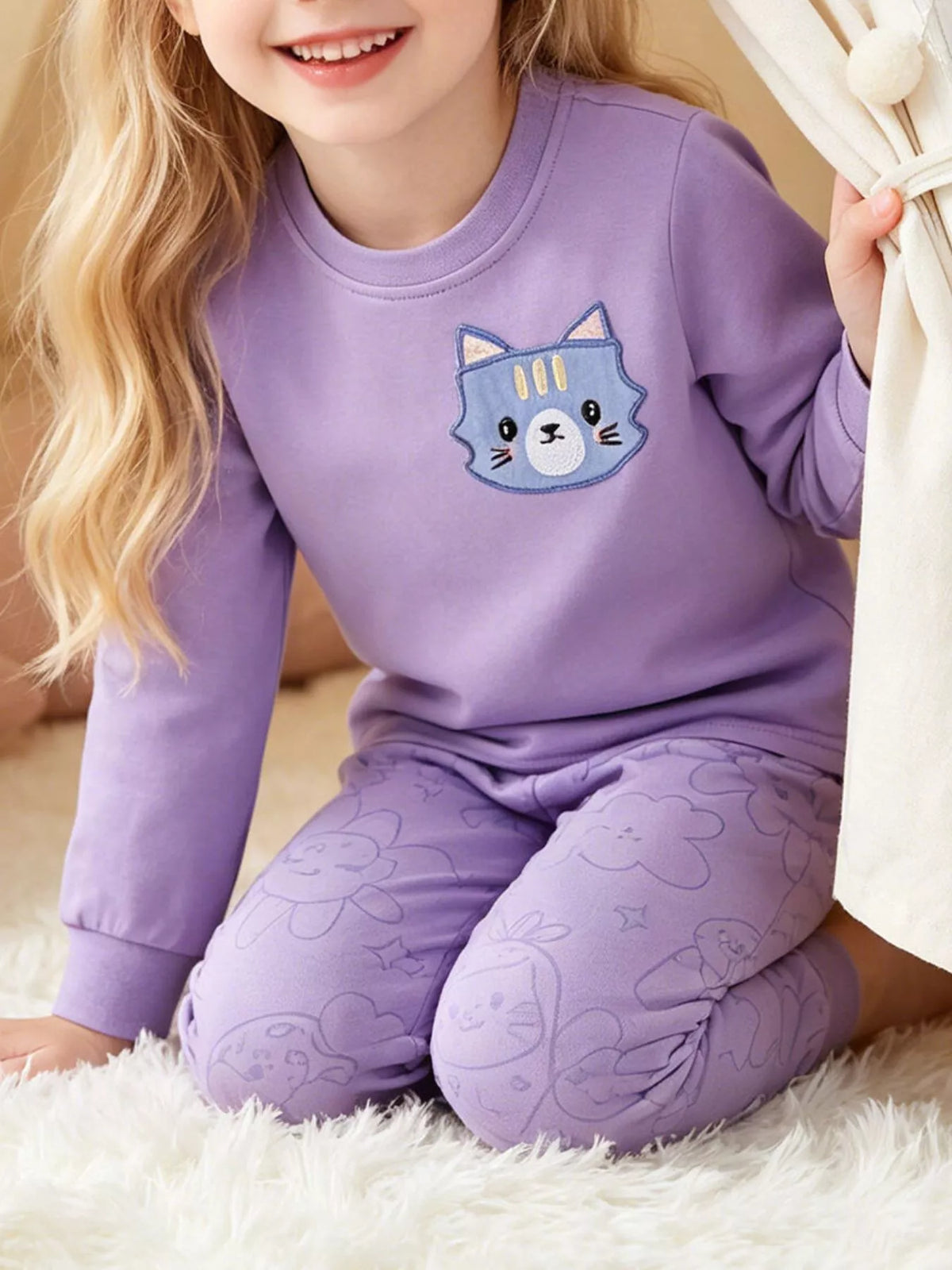Purple cat graphic sweatshirt and matching pants worn by a child
