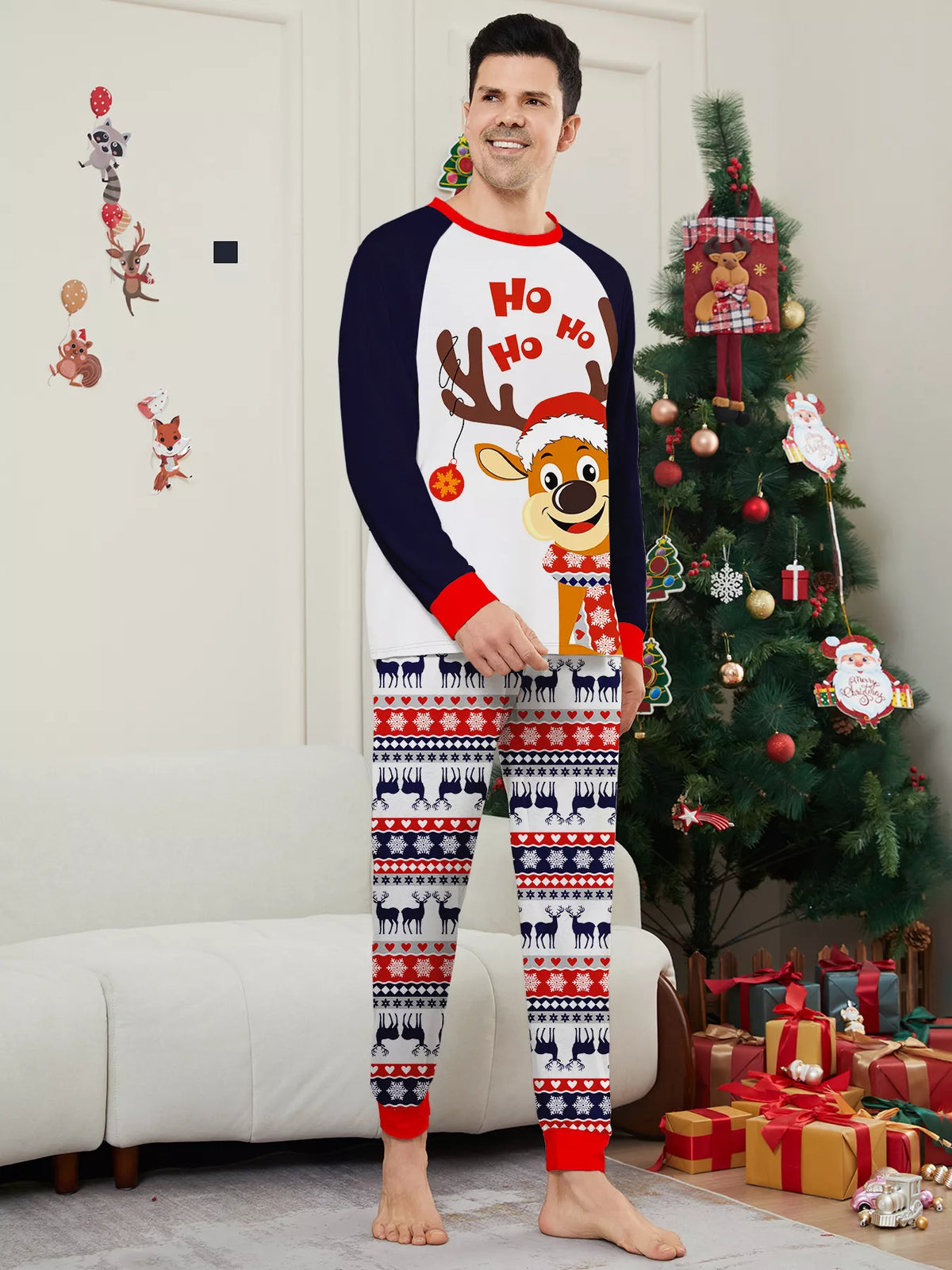 Man modeling a white reindeer Christmas graphic top with navy sleeves and festive striped pajama pants.