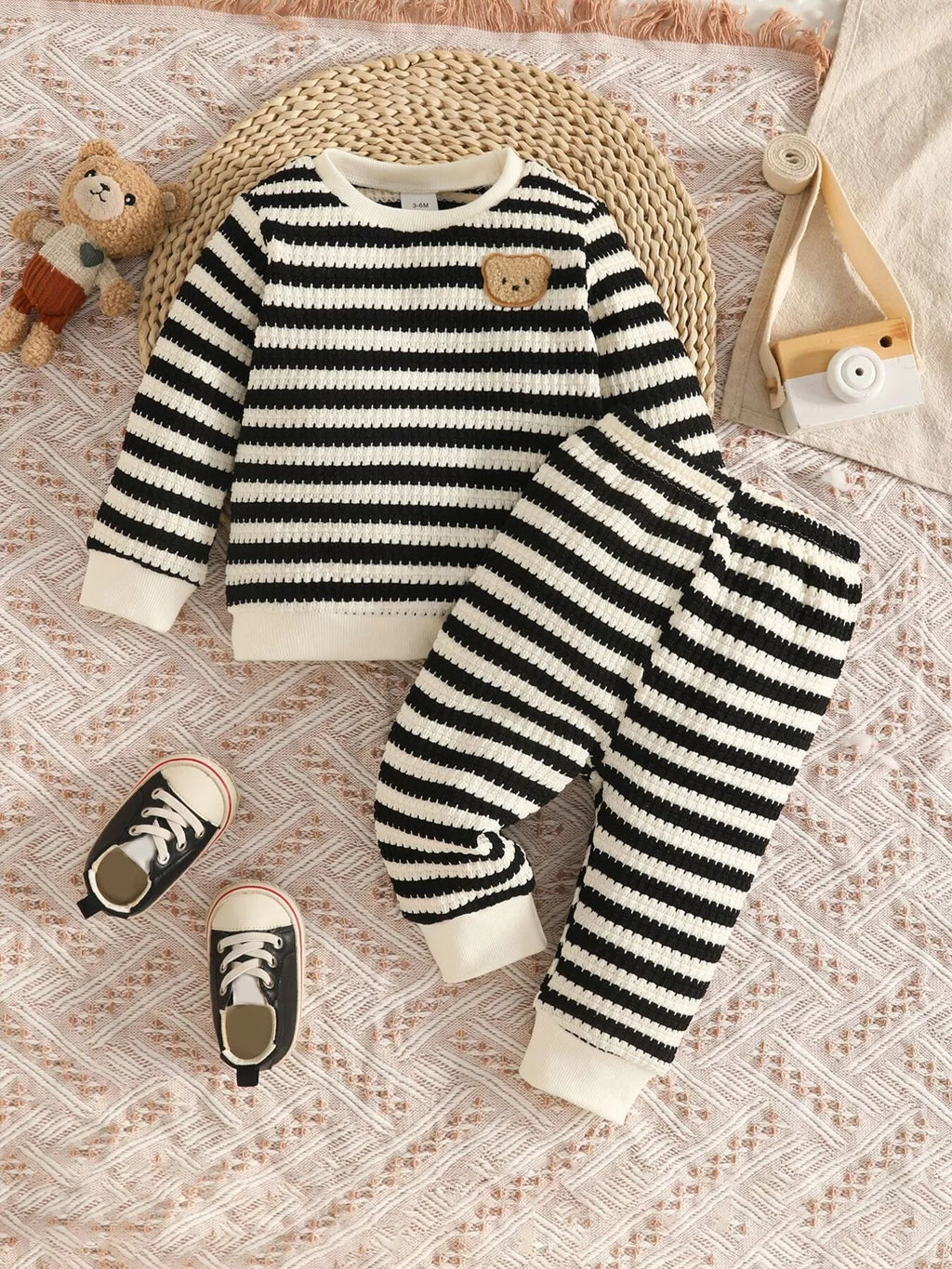Black and cream striped knit top and matching pants displayed flat