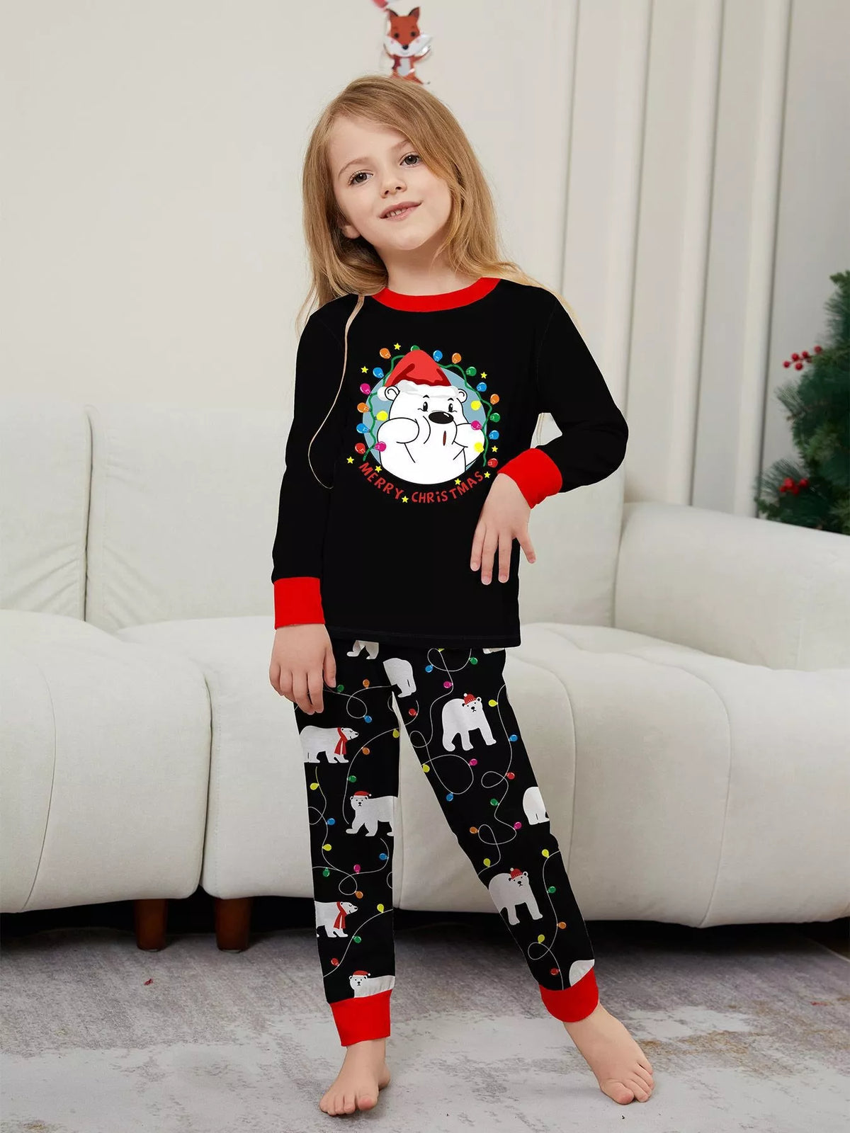 Child wearing the black Christmas pajamas with contrasting red cuffs.