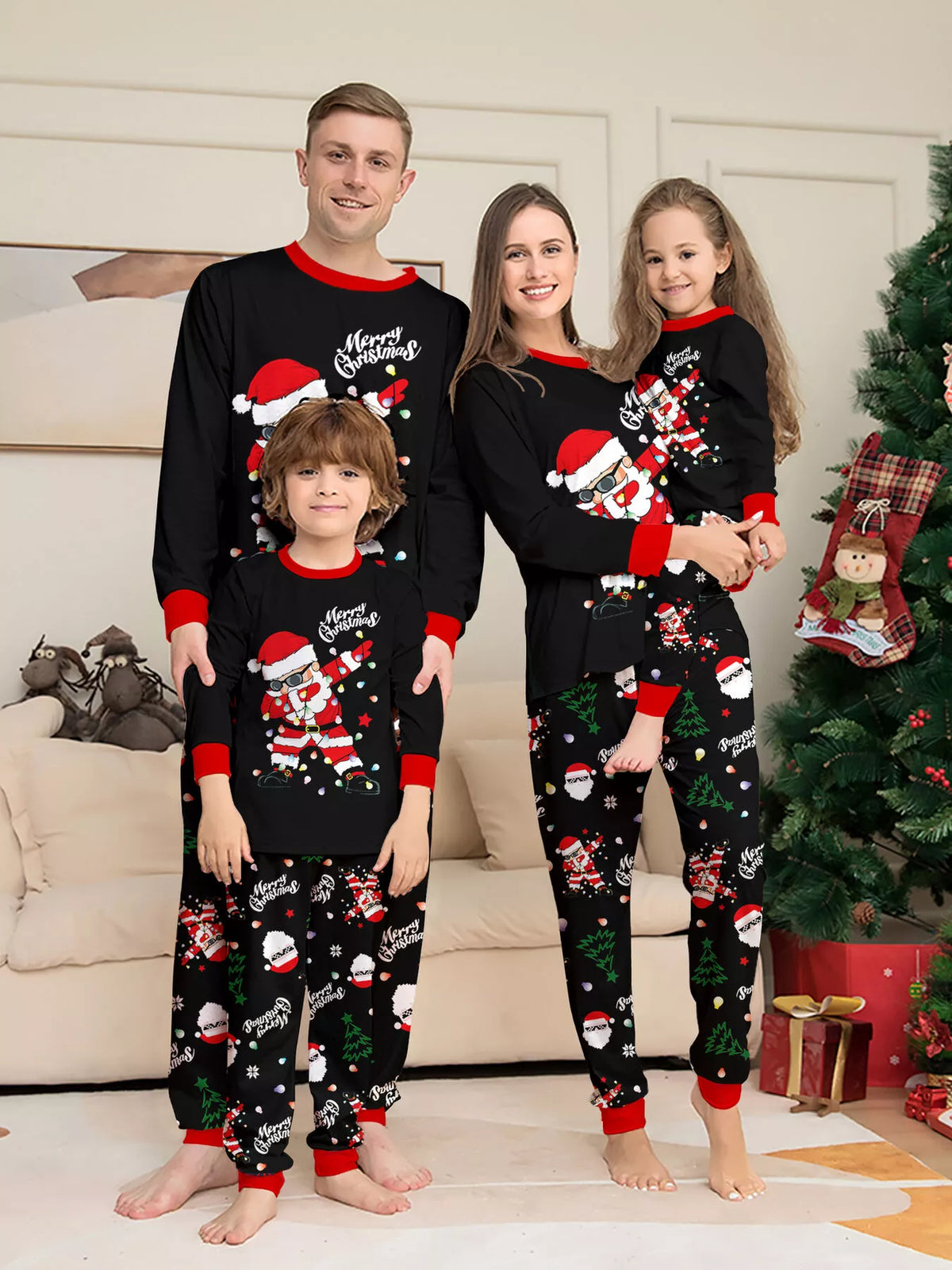 Family wearing black Santa graphic tops and black Christmas-print pajama pants.