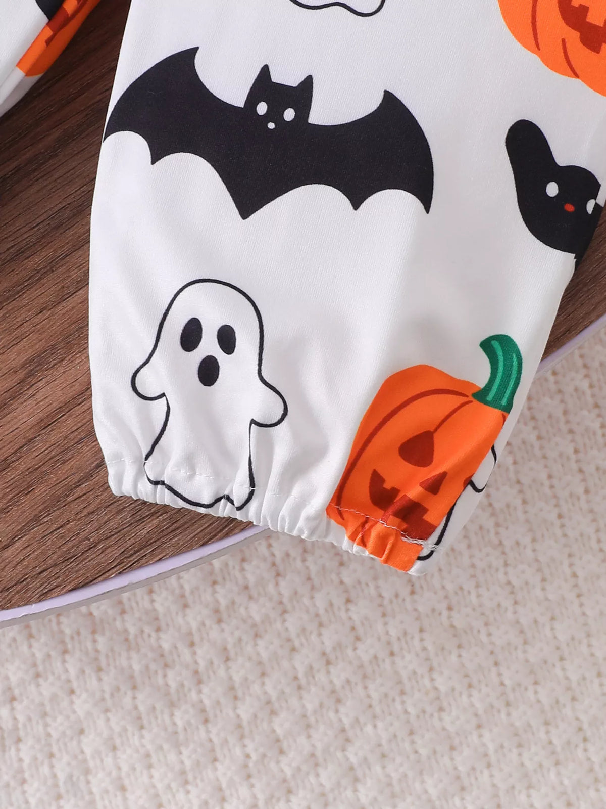Close-up of the white pants' ghosts, bats, pumpkins and Halloween print.