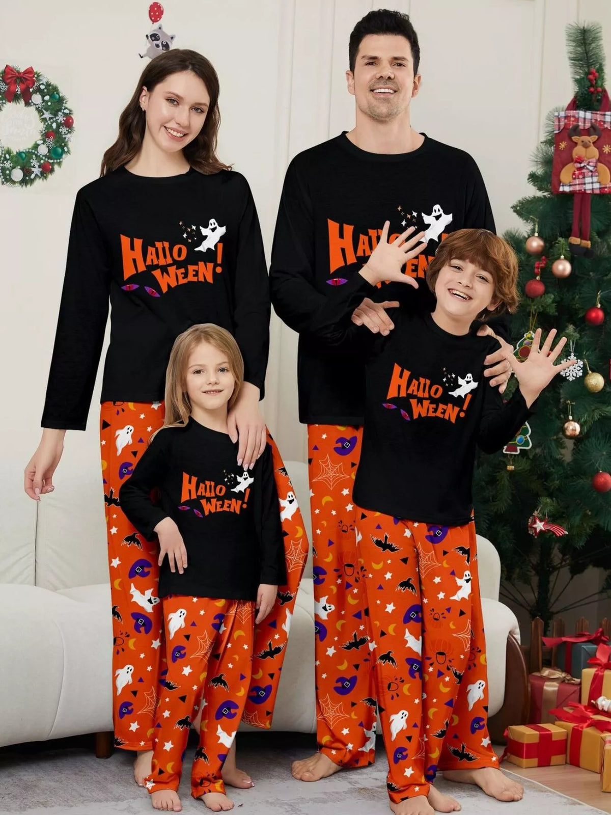 Family wearing matching black Halloween graphic tops and orange printed pajama pants.