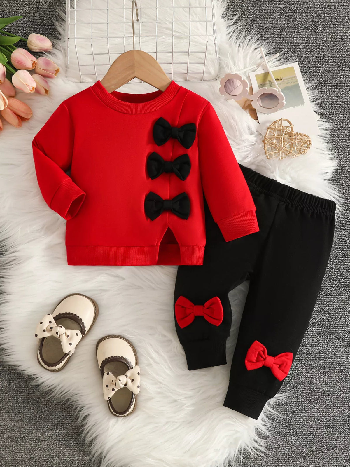 Red top with black bow appliques and black pants with red bows.
