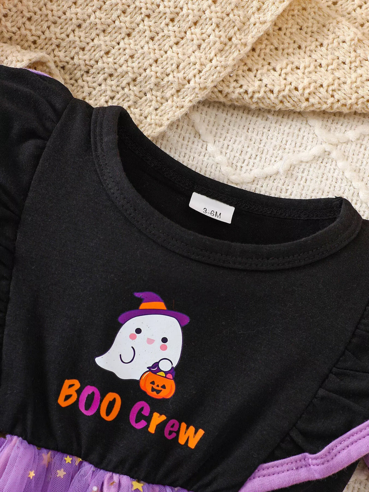 Close-up of the Boo Crew ghost graphic on the black dress bodice.