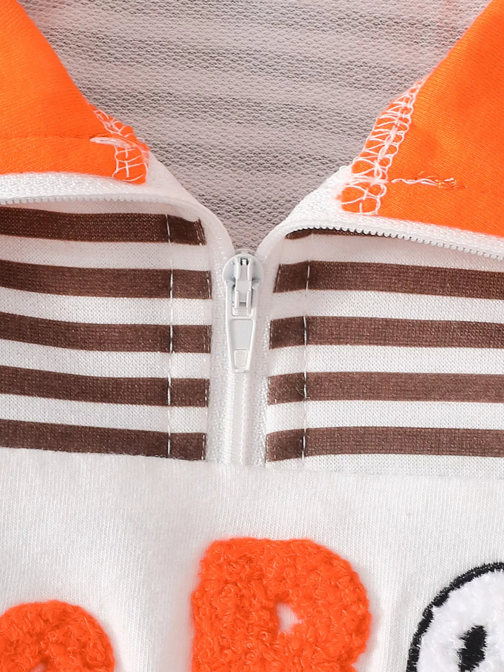 Close-up of the striped top's half zipper and orange collar stitching.