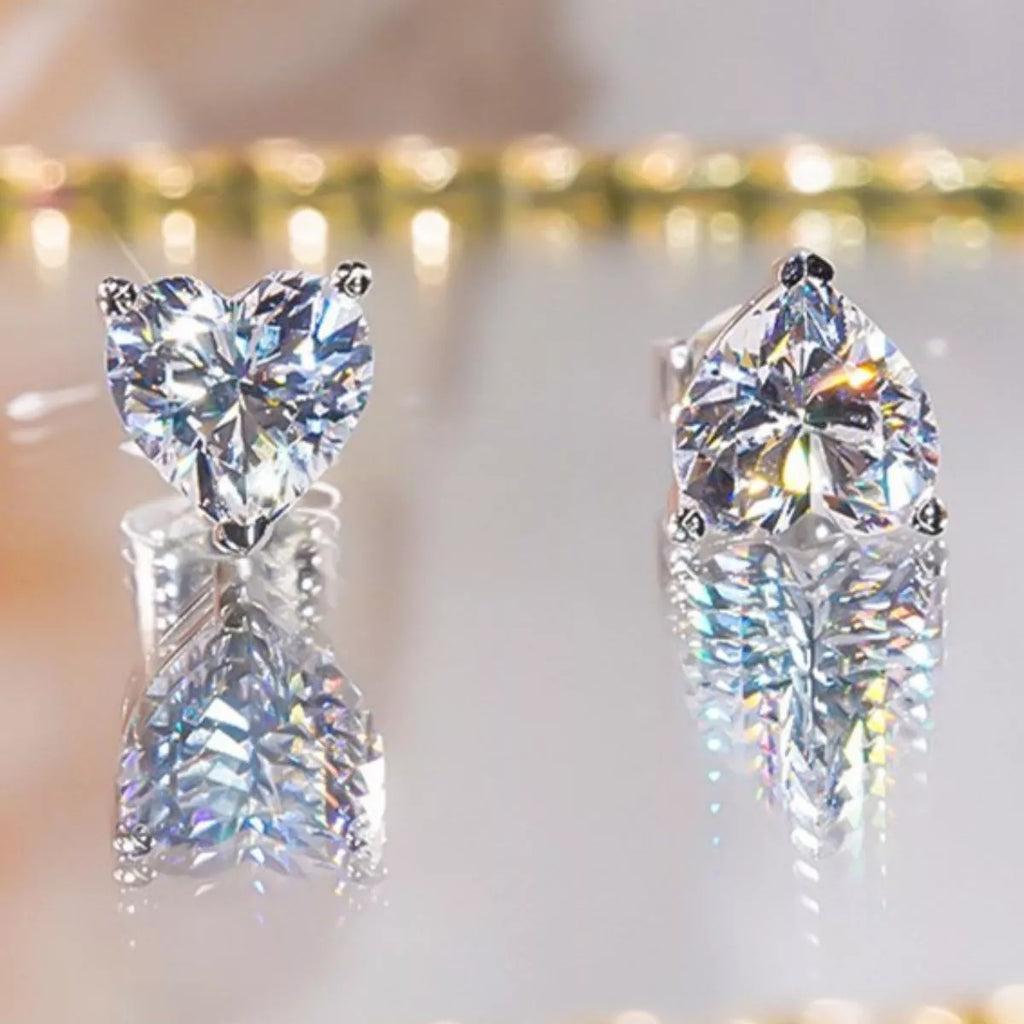 Silver-tone heart-shaped clear stone stud earrings — detail view