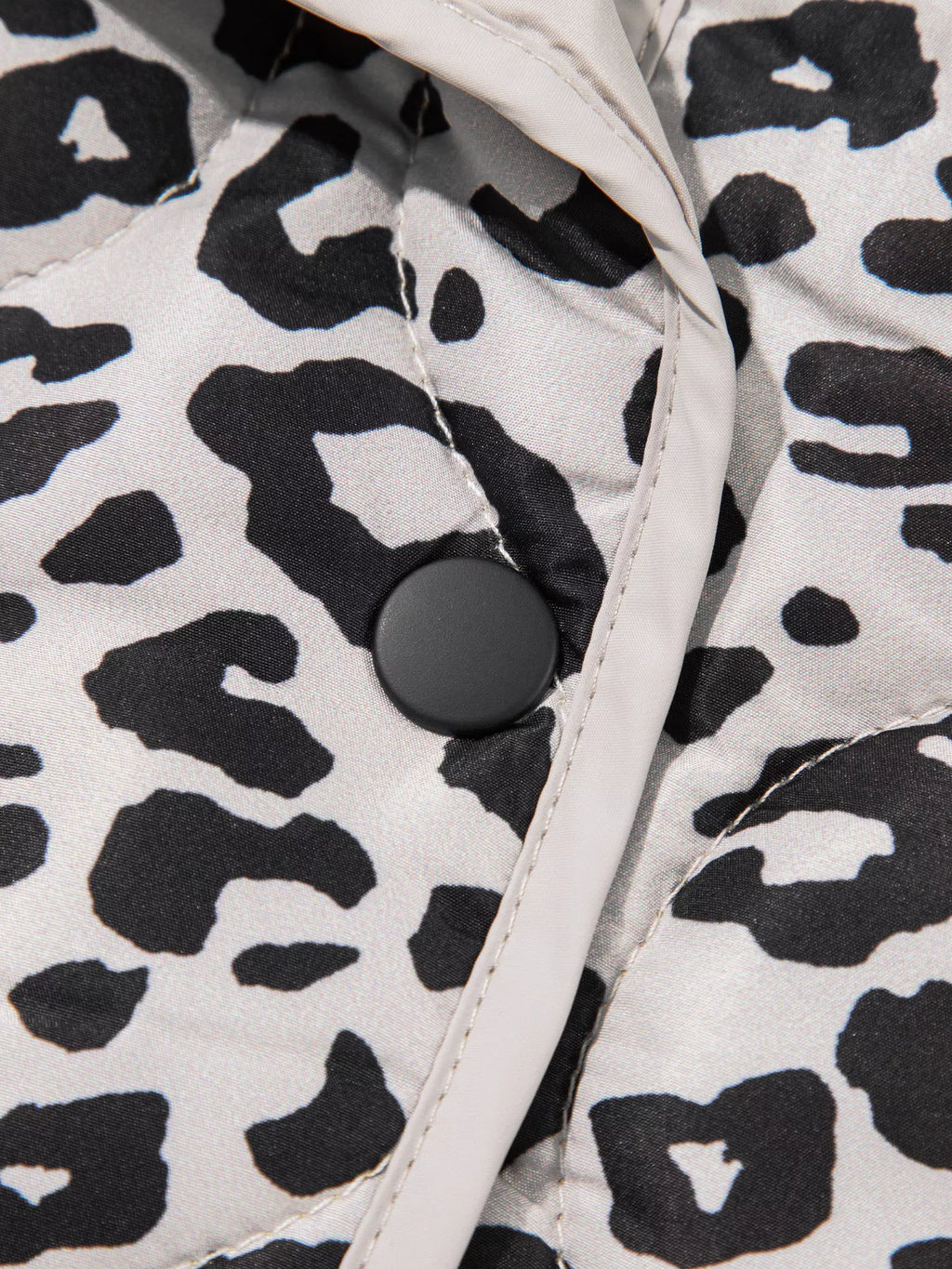 Close-up of the jacket's snap button and contrast front binding.