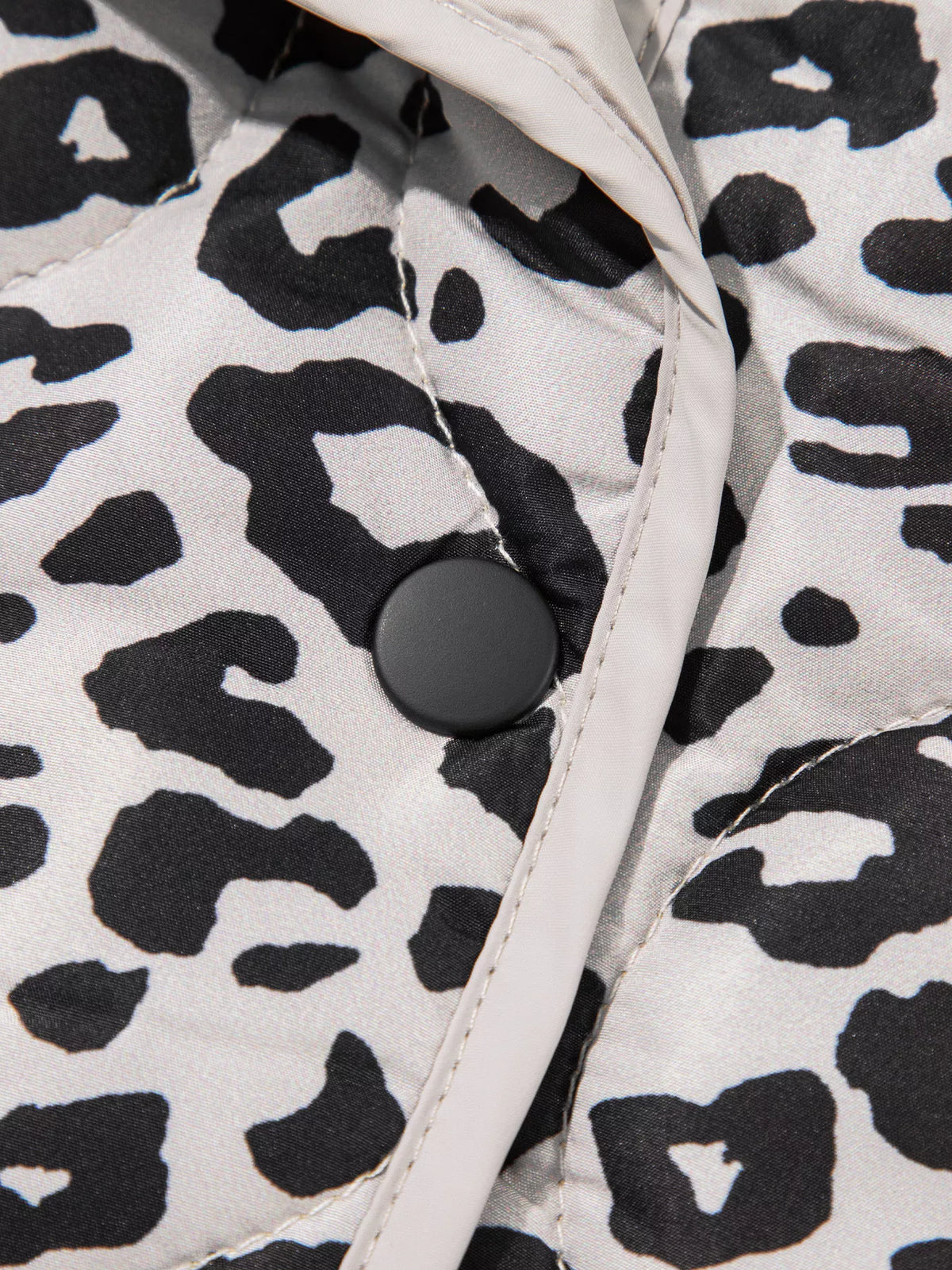 Close-up of the jacket's snap button and contrast front binding.
