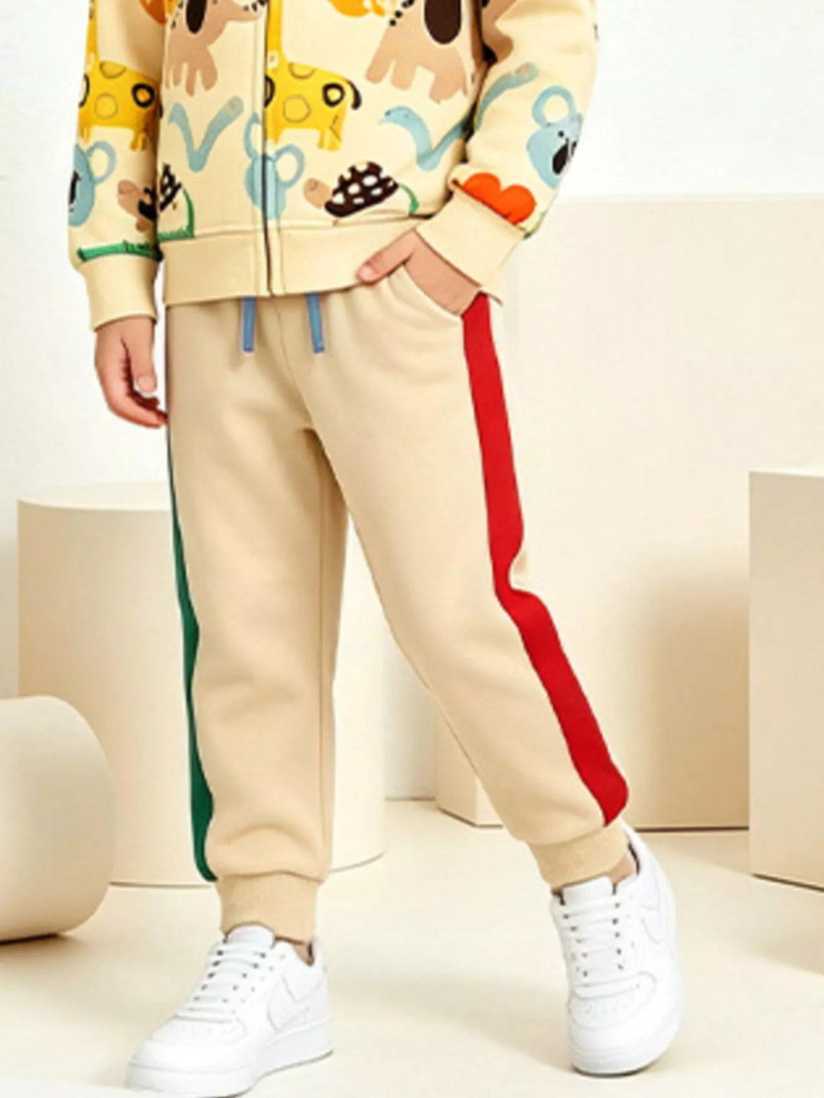 Close view of the cream pants with contrasting red side stripe.