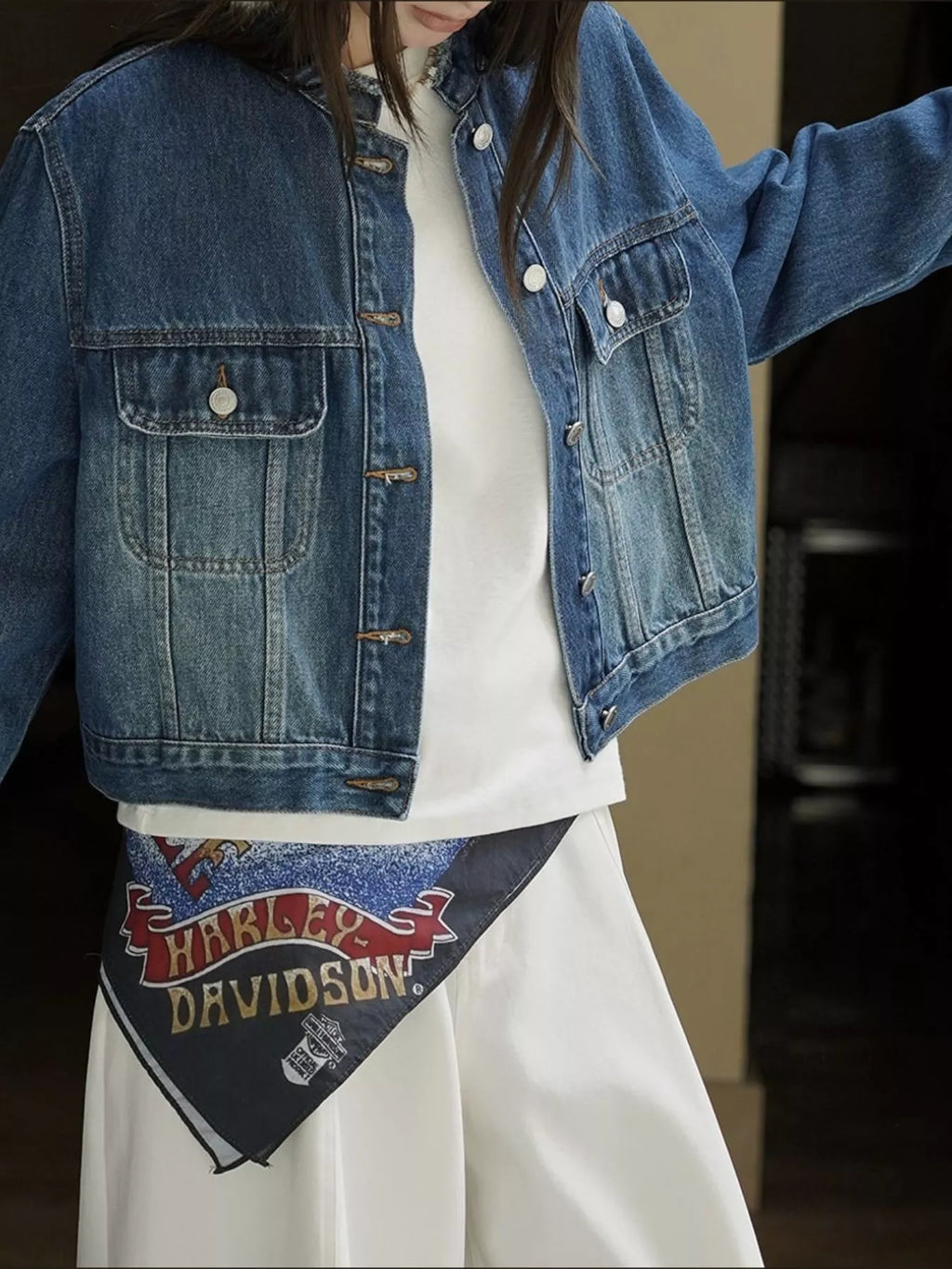 Close view of the blue denim jacket's chest pockets and seams.