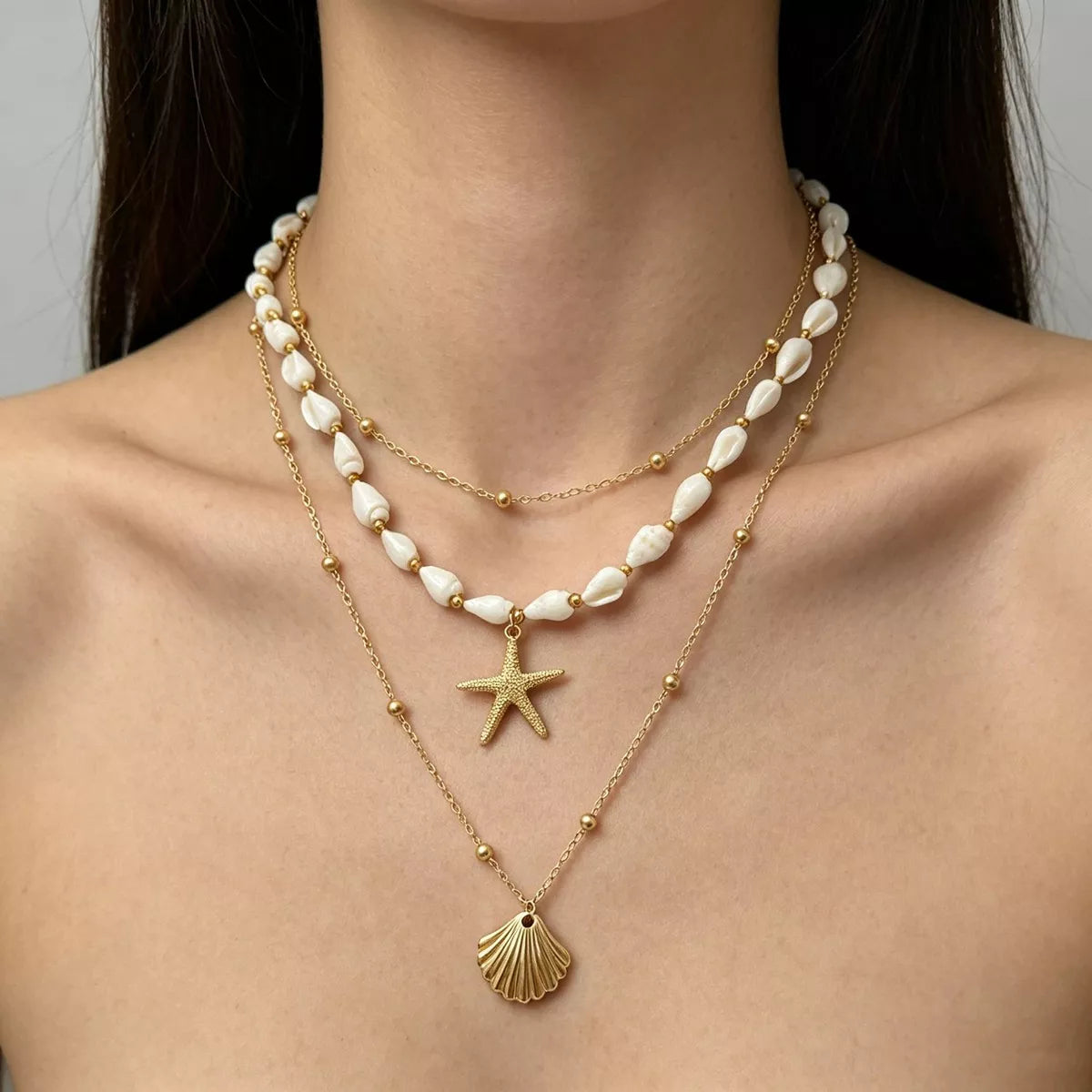 Layered gold-tone shell and starfish charm necklace