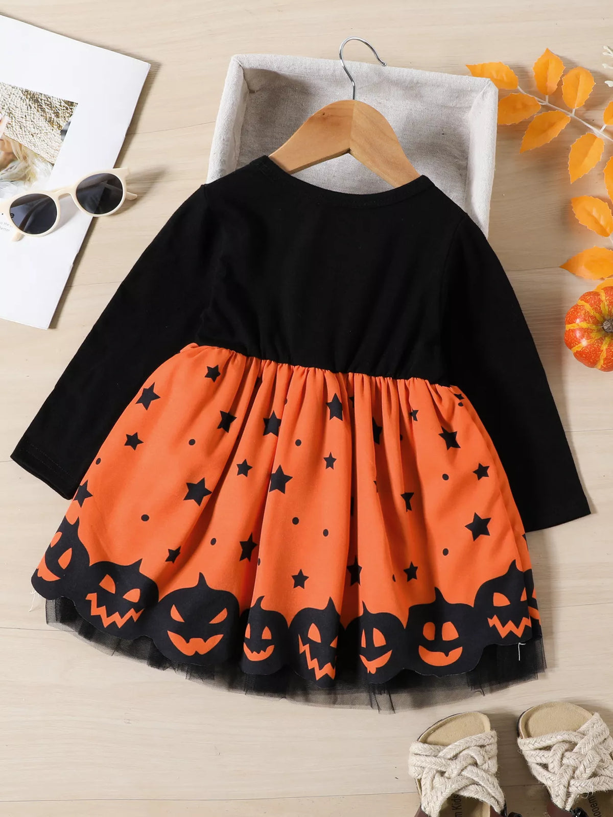 Back of the black and orange pumpkin-print children’s dress