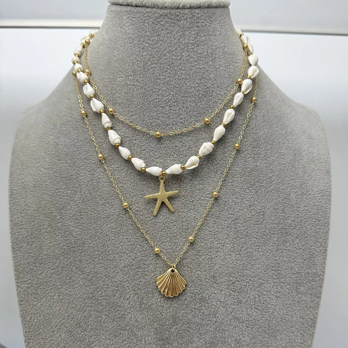 Layered gold-tone shell and starfish charm necklace