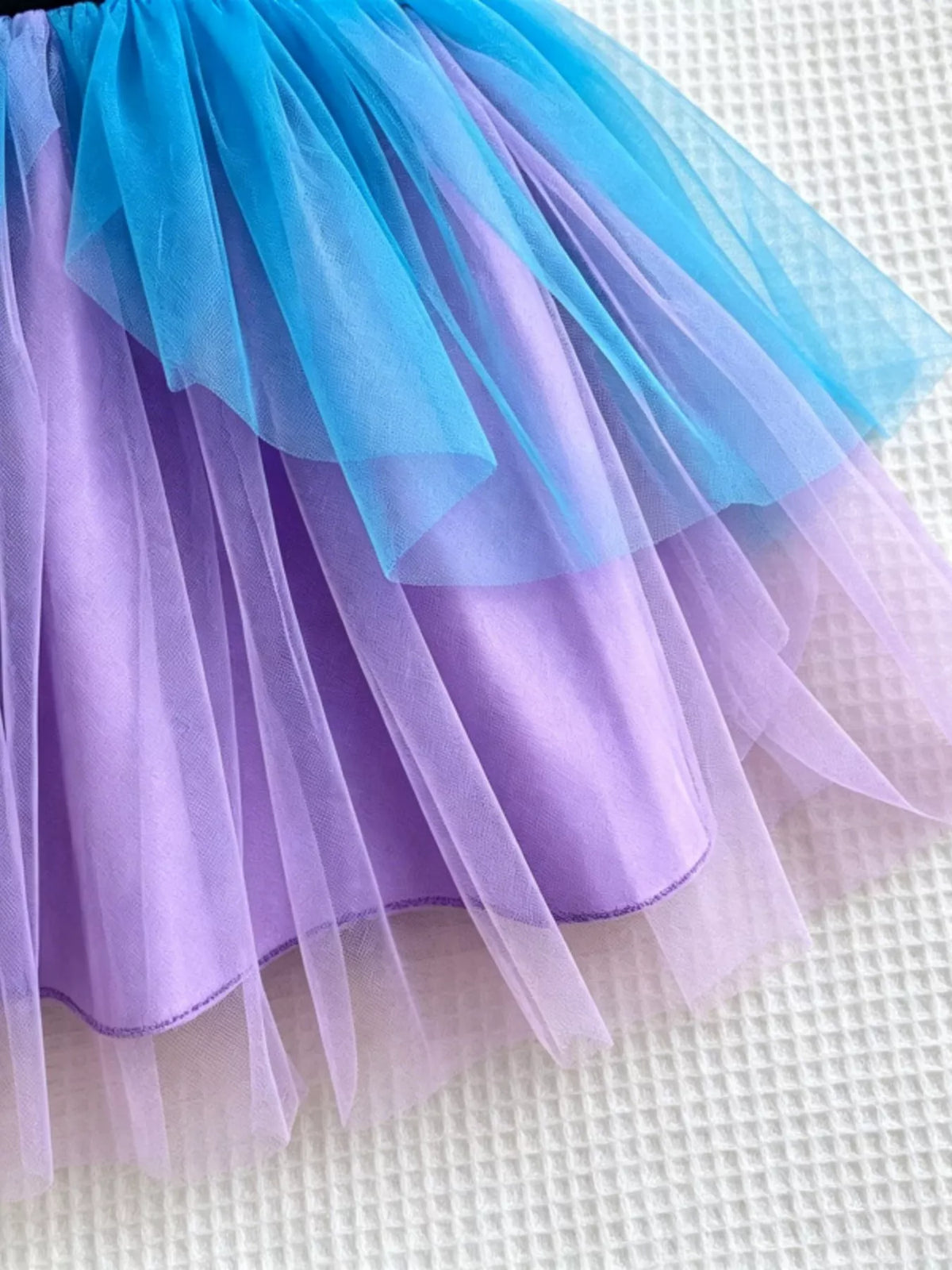 Close-up of blue and purple tulle skirt layers and purple lining.
