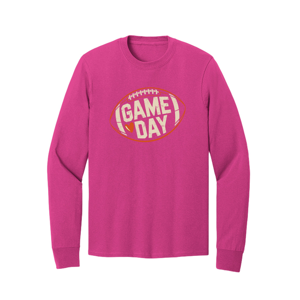 Front view of a bright pink long-sleeve T-shirt with cream Game Day lettering and a heart inside an orange football outline.