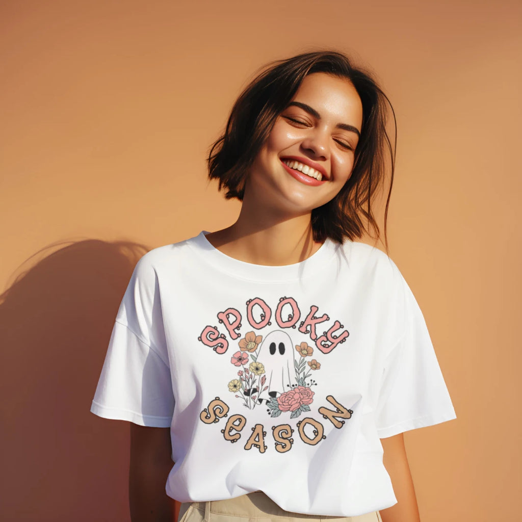 Person wearing a white Spooky Season Floral Ghost graphic T-shirt.