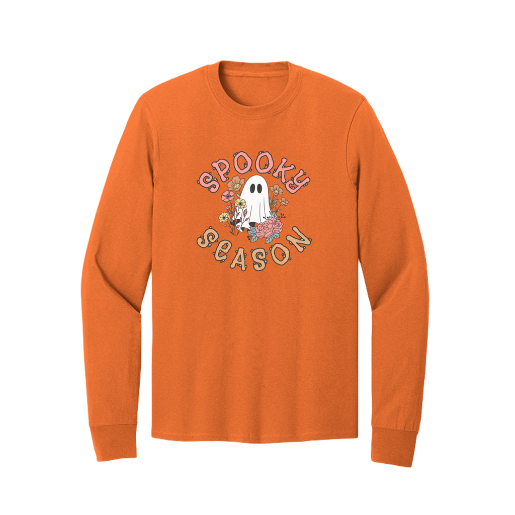 Front view of a orange long-sleeve T-shirt showing Spooky Season lettering around a white ghost surrounded by pink, orange, and yellow flowers.