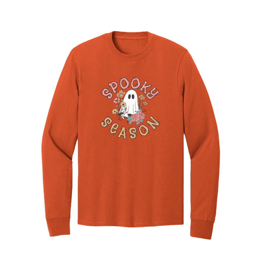 Front view of a orange long-sleeve T-shirt showing Spooky Season lettering around a white ghost surrounded by pink, orange, and yellow flowers.