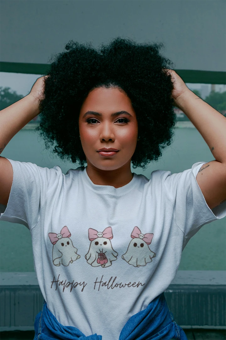 Person wearing a white Happy Halloween Pink Bow Ghost Trio graphic T-shirt.